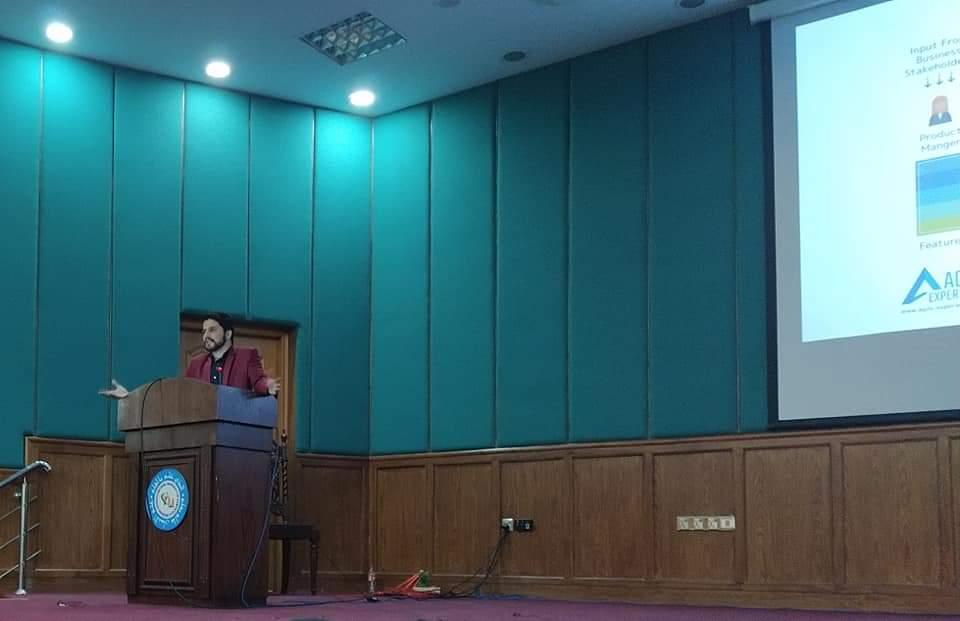 Abid Jamil speaking at a lectern during his mobile architecture talk at FAST NUCES